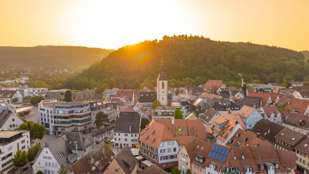 Luftaufnahme der Nagolder Altstadt mit Stadtkirche, Fachwerkhaus und Schlossberg im Abendlicht, Immobilienmakler für den Verkauf in Nagold, Steffen Meyer Immobilien